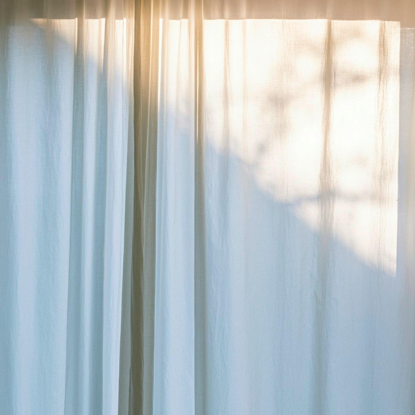 Light through a drawn net curtain