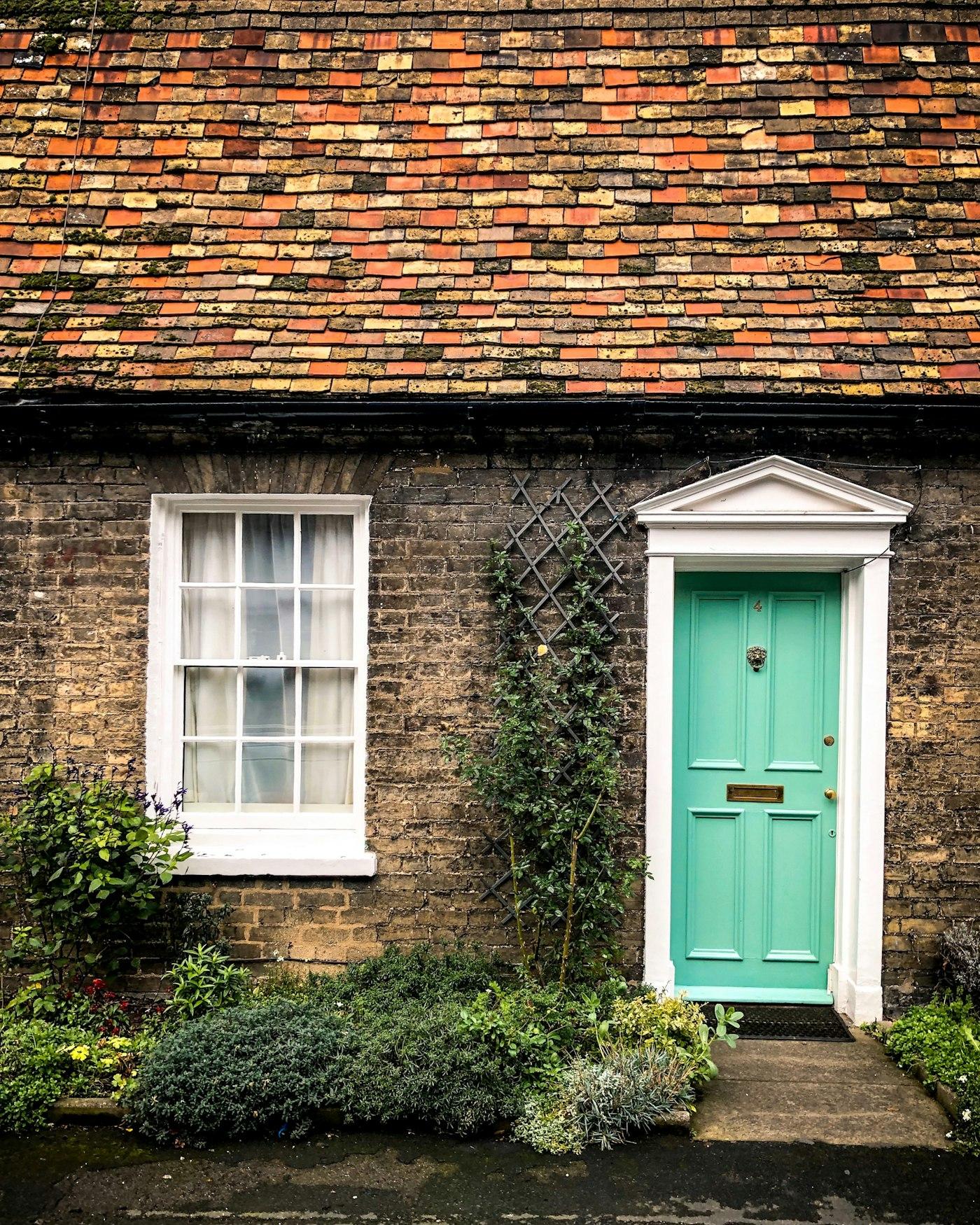 A green front door on a brick cottage